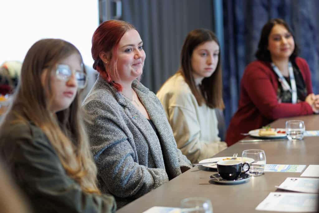 young islanders at a table smiling at meeting